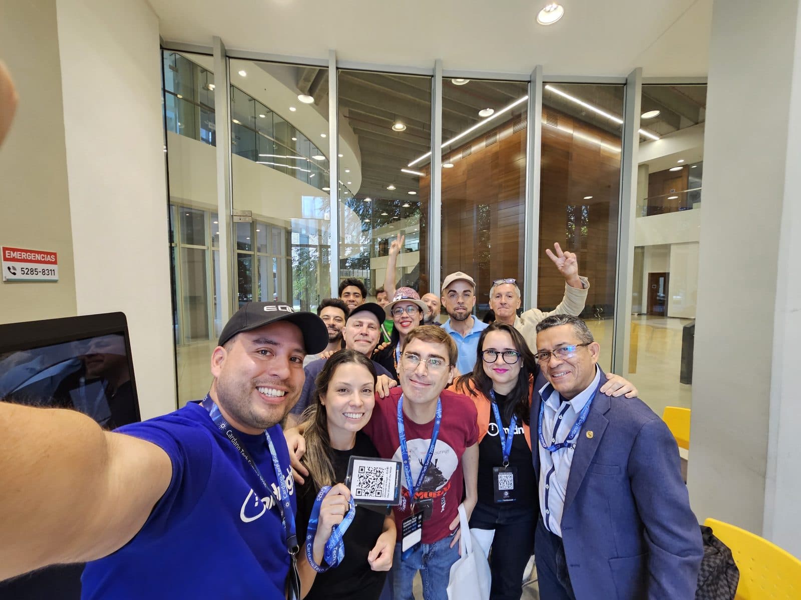 A group photograph after the Buenos Aires session, lanyards on, one participant holding up a QR code.